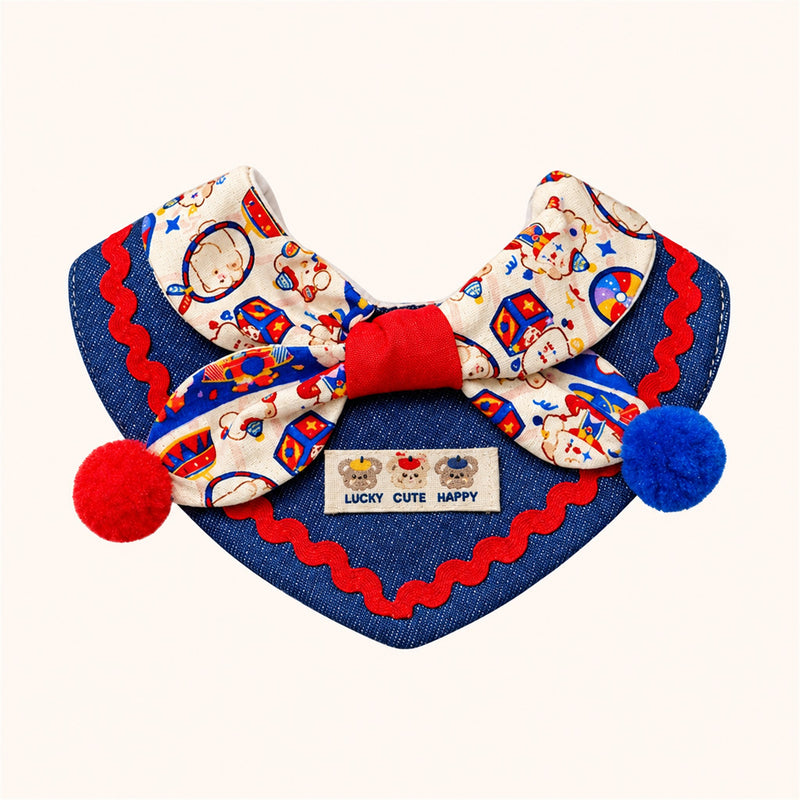 AI-cleaned product photo: Circus Bear big bow pet bib, denim bib with a circus-print bow and red & blue pompoms
