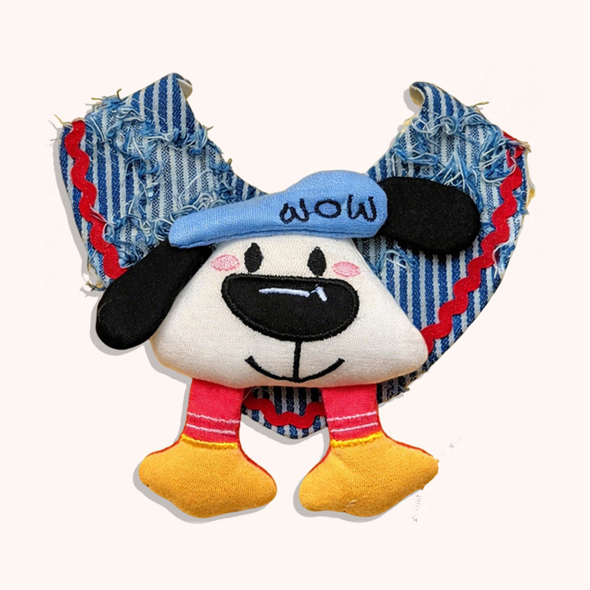 AI-cleaned product photo: Denim Pup pet bib, striped denim with a plush pup face, blue cap and dangling legs