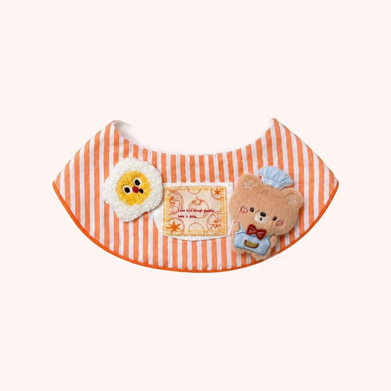Product photo: Chef Bear Pet Bib — Orange-striped bib with a fluffy fried egg, a recipe patch and a plush chef bear.