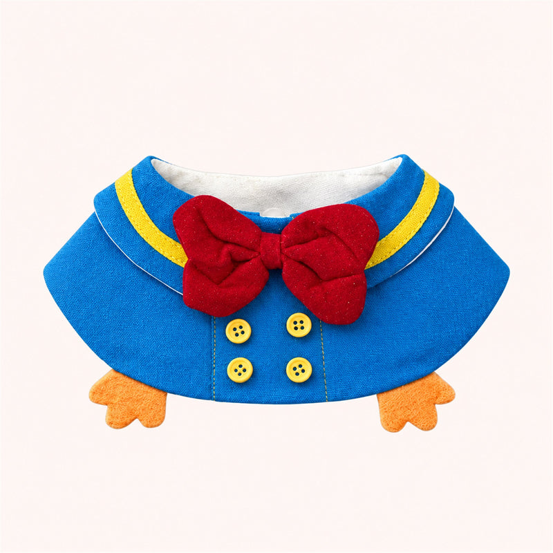 AI-cleaned product photo: Sailor Duck Bow Pet Bib — Sky-blue sailor collar with a red bow, yellow buttons and two little plush duck feet.