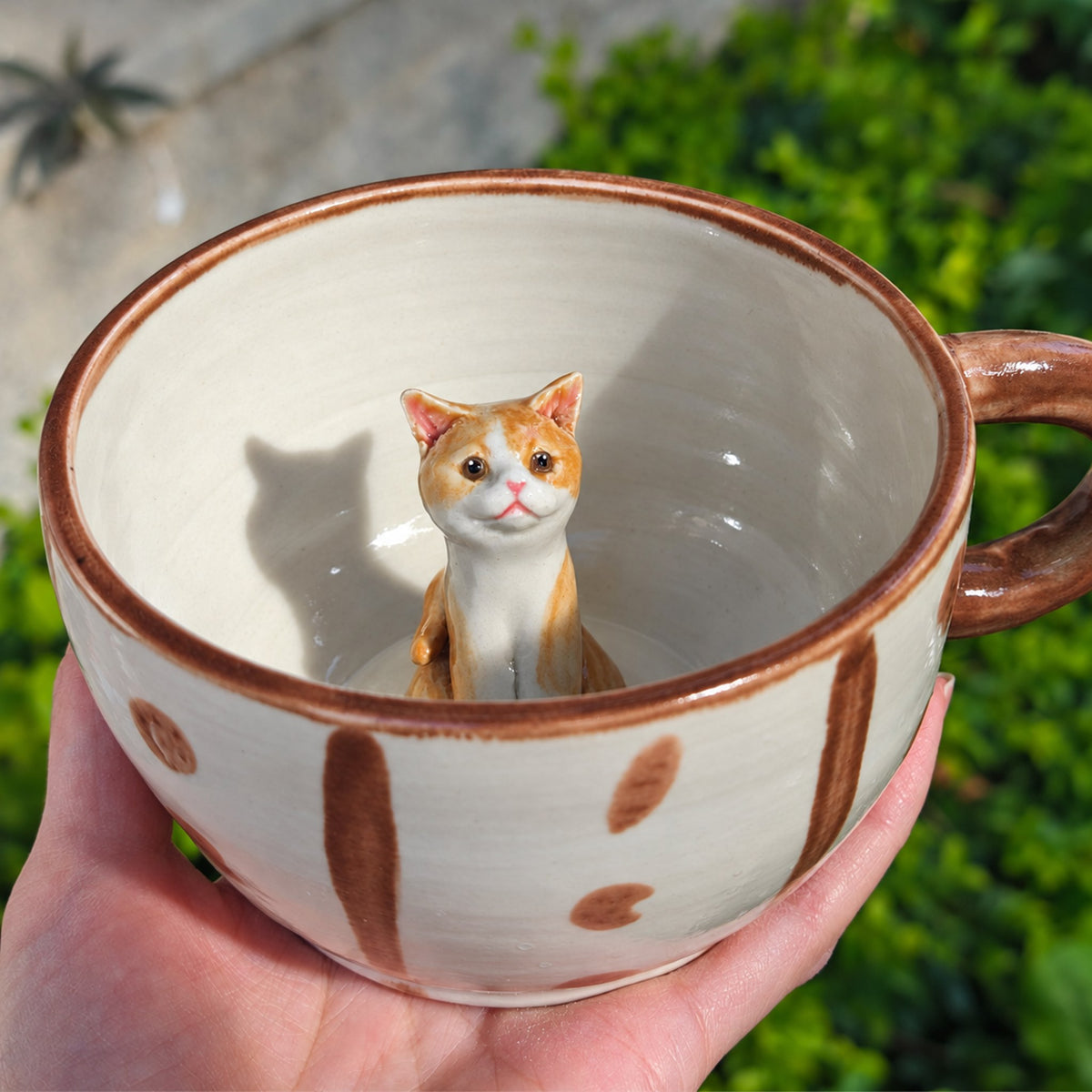 AI-cleaned product photo: Peeking inside pose, sculpted cat sitting inside the mug