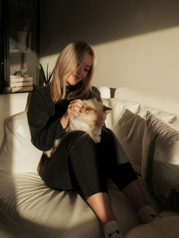 Woman on the couch holding her cat